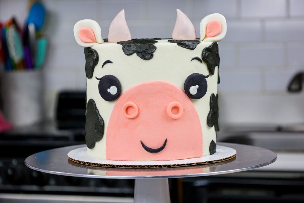 image of an adorable buttercream cow birthday cake made with marbled chocolate and vanilla cake layers