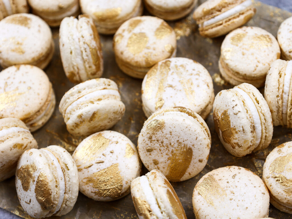 image of vanilla macarons made using the french method and decorated with edible gold paint