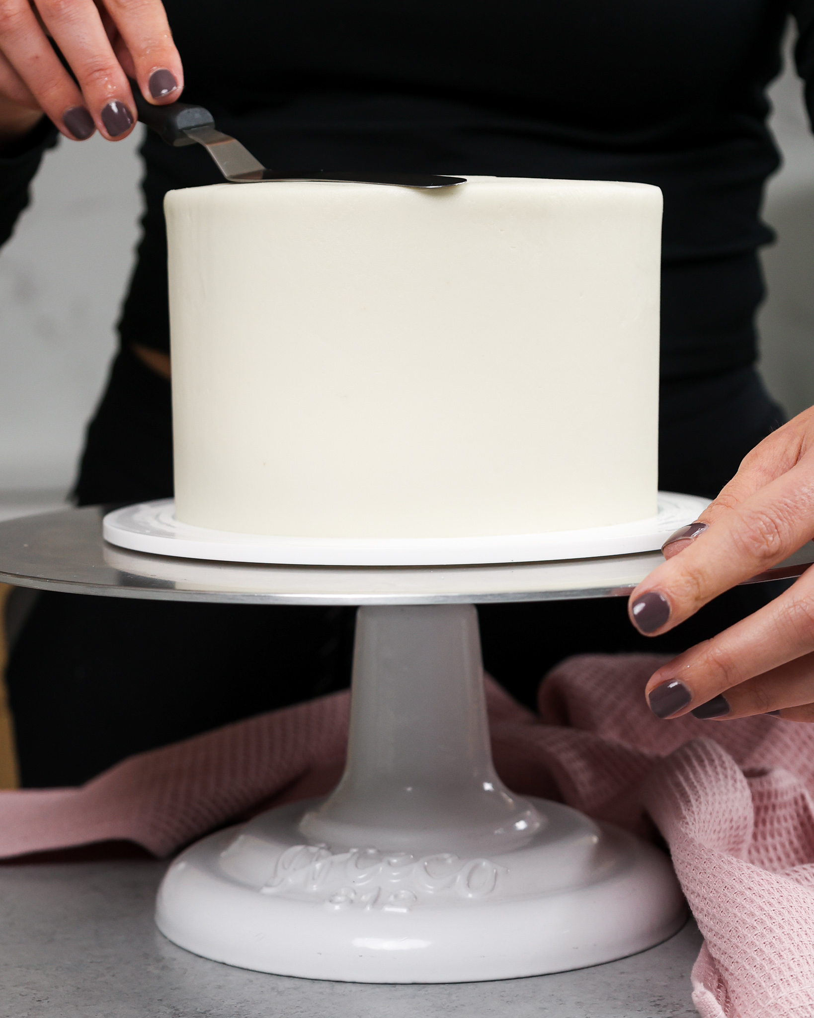 image of a 6-inch layer cake that's being frosted smoothly with vanilla buttercream frosting