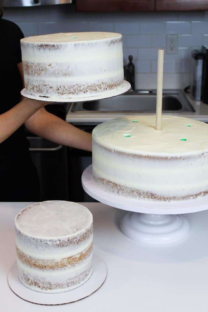 Photo of semi-naked cake tiers about to be stacked