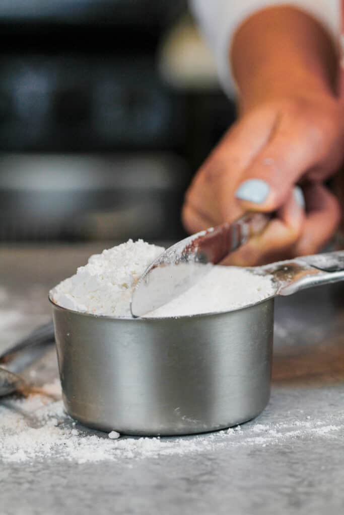 image of flour being leveled in a measuring cup