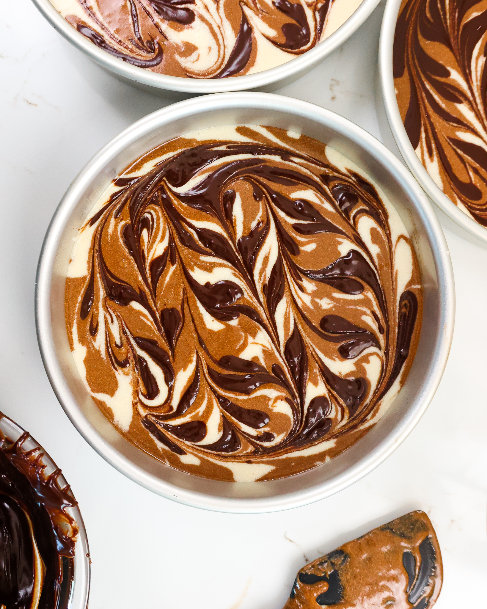 image of chocolate and vanilla marble cake layers that have been swirled with a fudge ripple and are ready to be baked