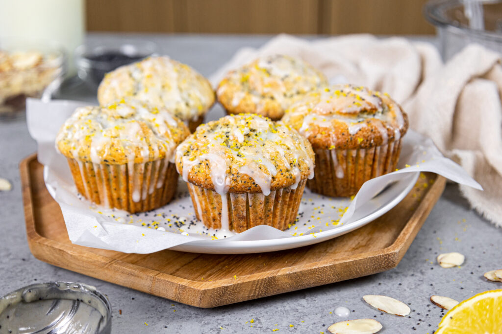 image of almond poppy seed muffins being glazed with almond glaze