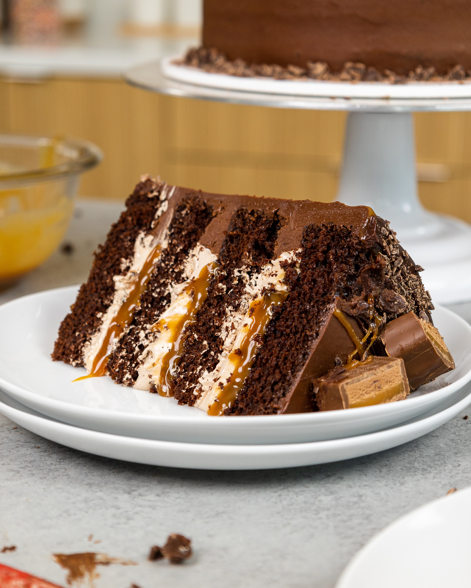 image of a slice of a milky way cake made with fluffy chocolate filling, homemade caramel filling, and moist chocolate cake layers