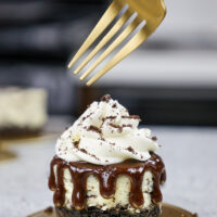 image of a mini oreo cheesecake topped with whipped cream and crushed oreos