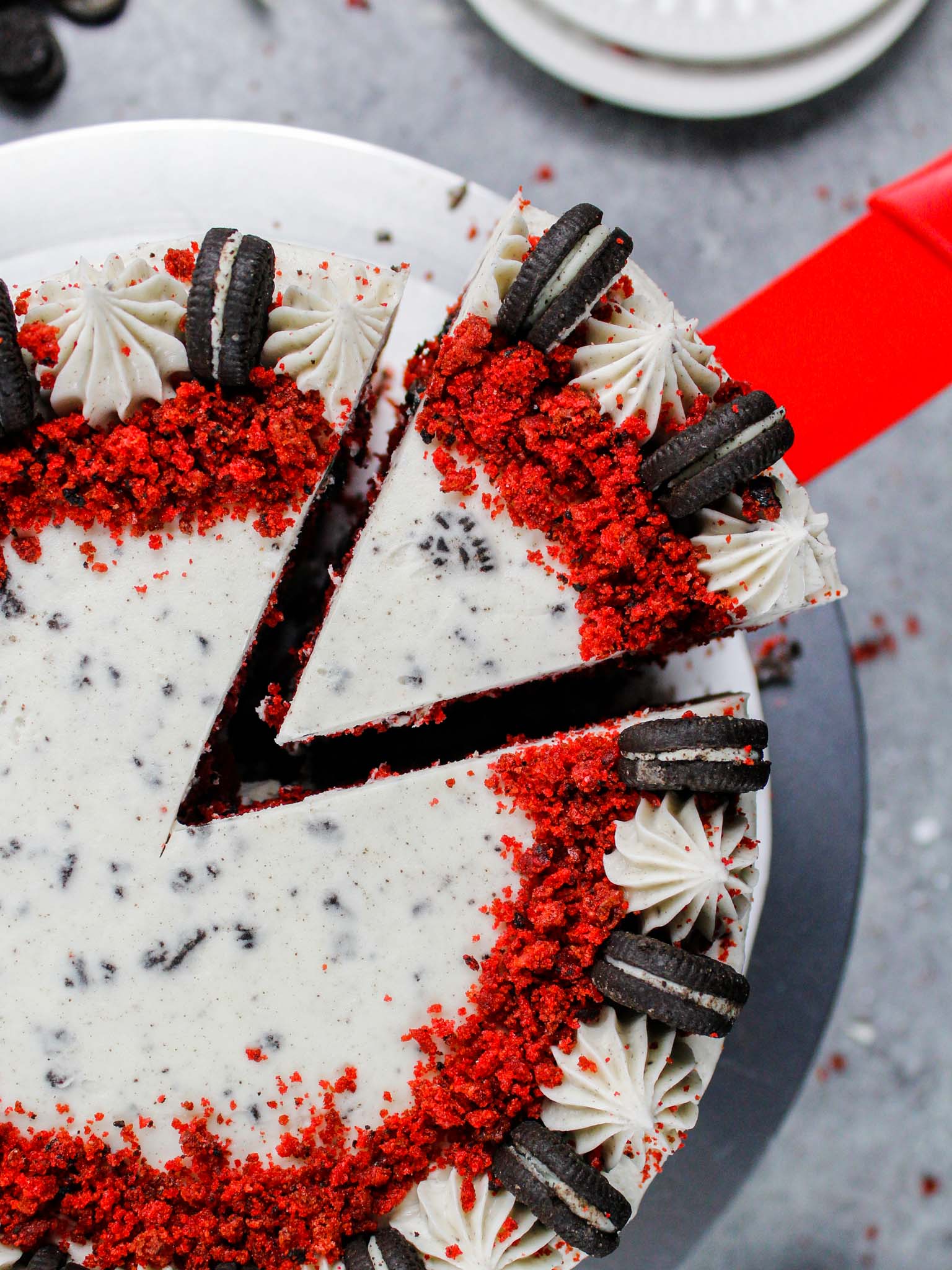 image of a slice of red velvet oreo cake that's frosted with an oreo red velvet cream cheese frosting