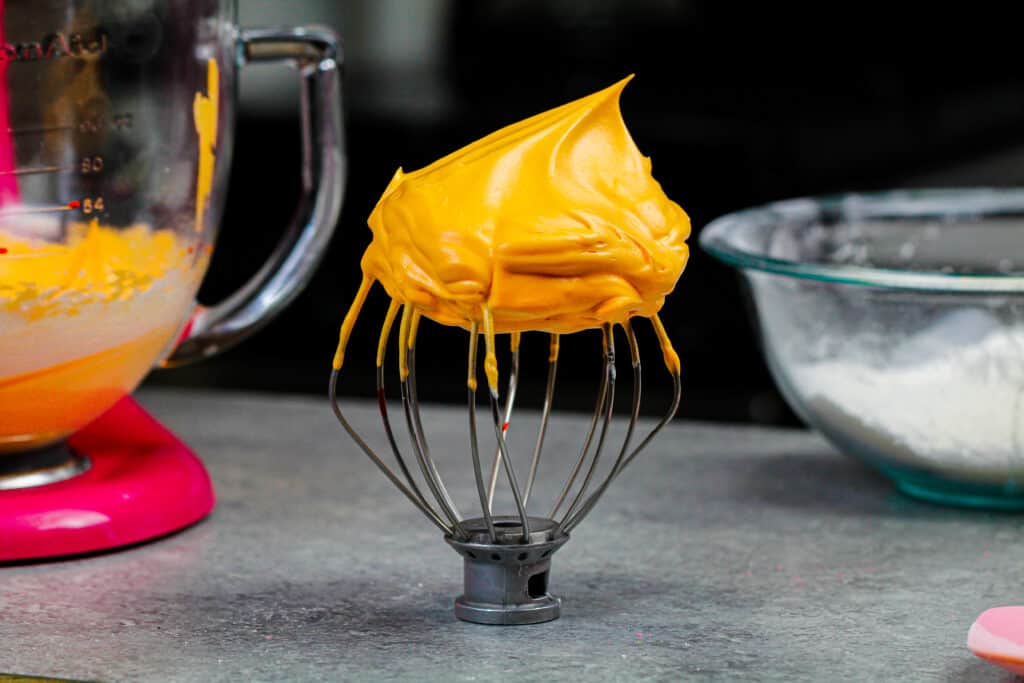 image of orange meringue on a whisk ready to be made into pumpkin macarons