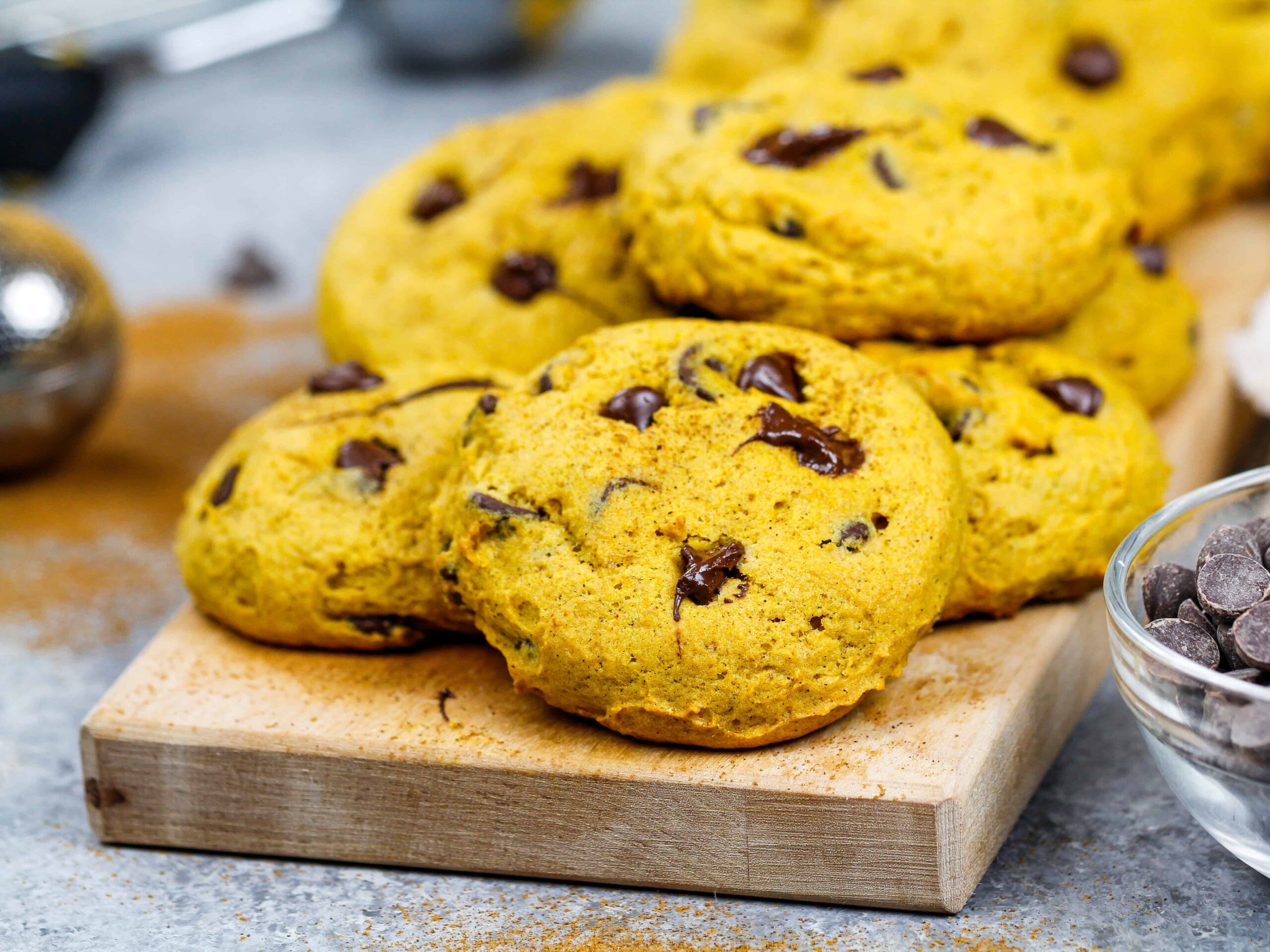 image of vegan pumpkin chocolate chip cookies stacked on a board ready to be eaten