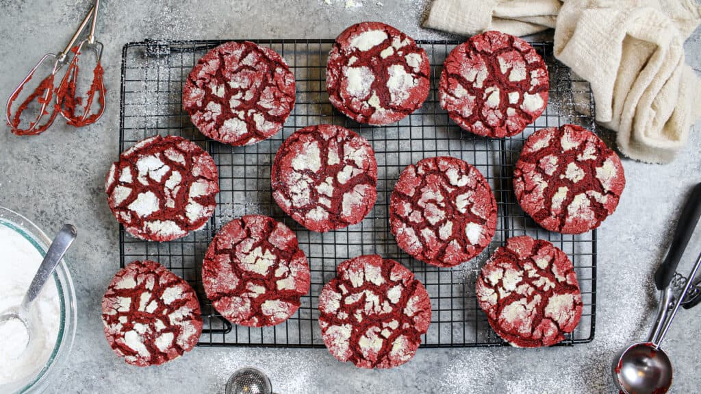 image of red velvet crinkle cookies made from scratch cooling on a wire rack
