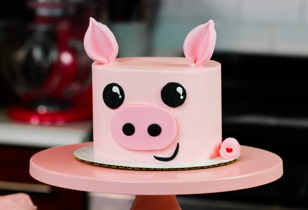 image of pig birthday cake on pink cake stand