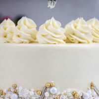 image of almond buttercream being piped on a WASC cake