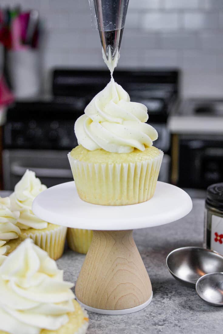 image of gluten free vanilla cupcake being frosted with vanilla bean buttercream