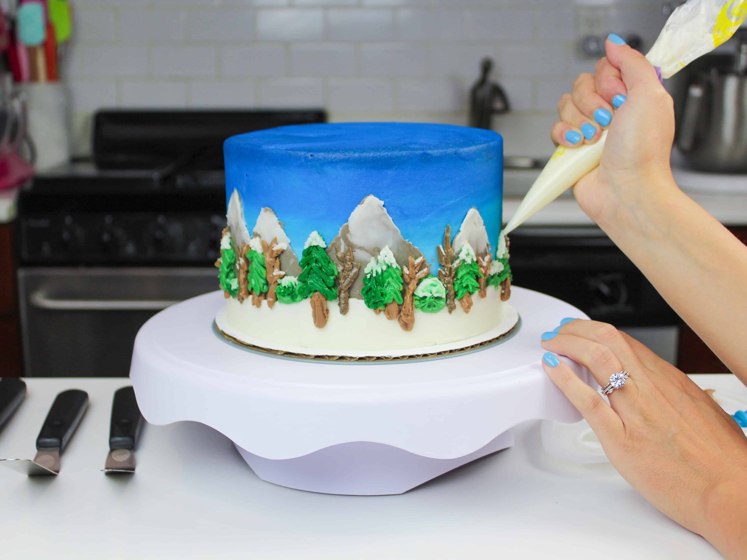 image of american buttercream being piped onto a detailed winter wonderland cake