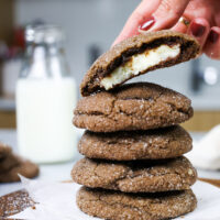 image of a chocolate cheesecake cooke that's been bitten into to show its creamy cheesecake filling