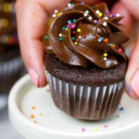 image of a mini chocolate cupcake being placed on a mini cake stand