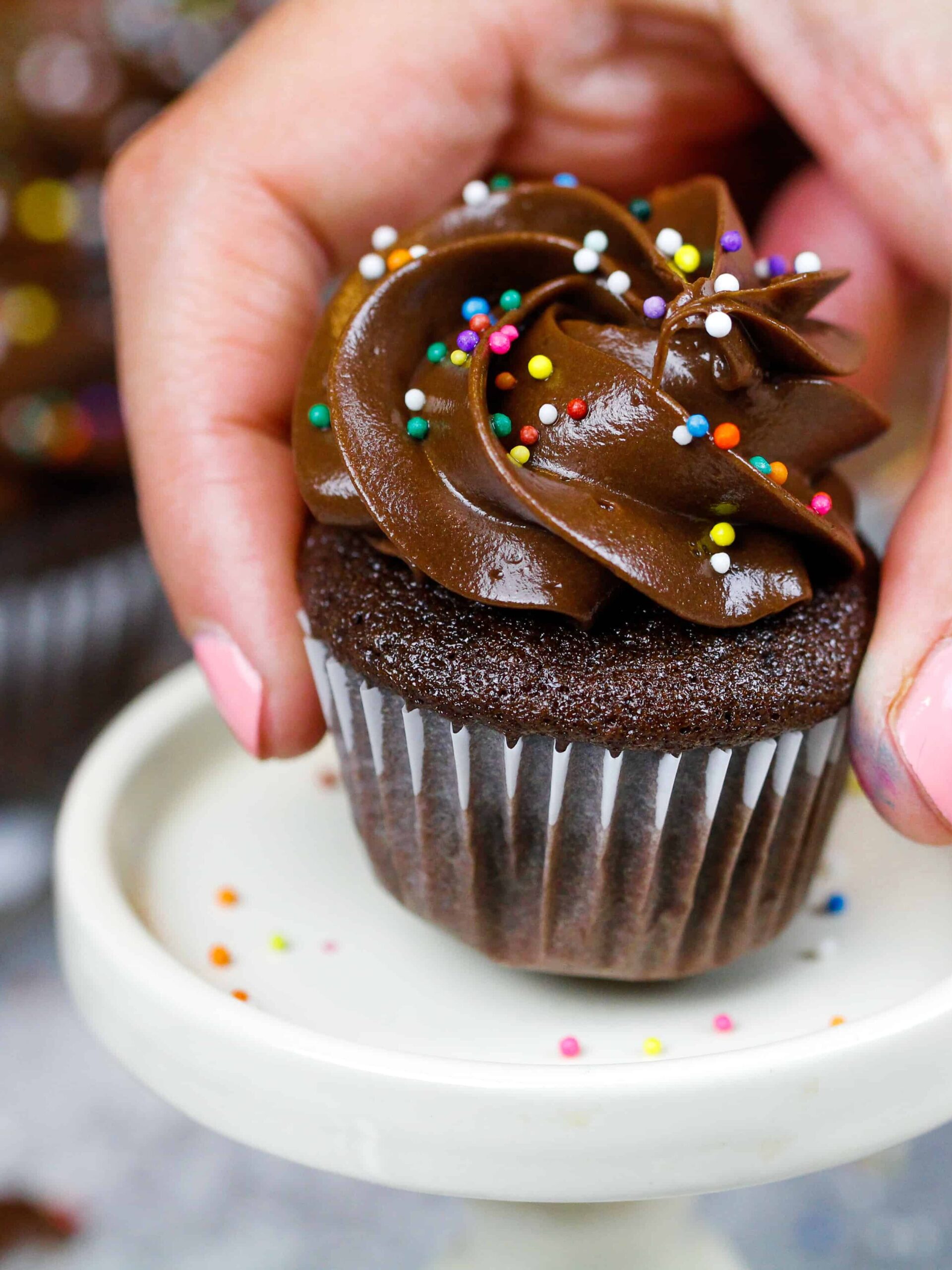 image of a mini chocolate cupcake being placed on a mini cake stand