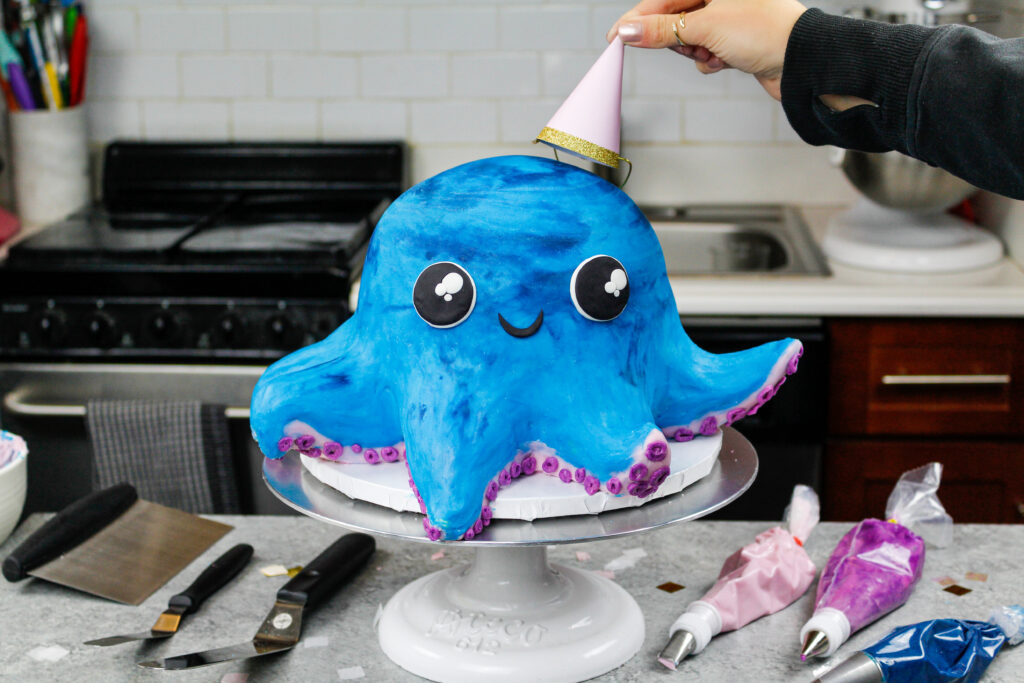 image of an octopus cake made with colorful cake layers, buttercream and cake decorating rice krispie