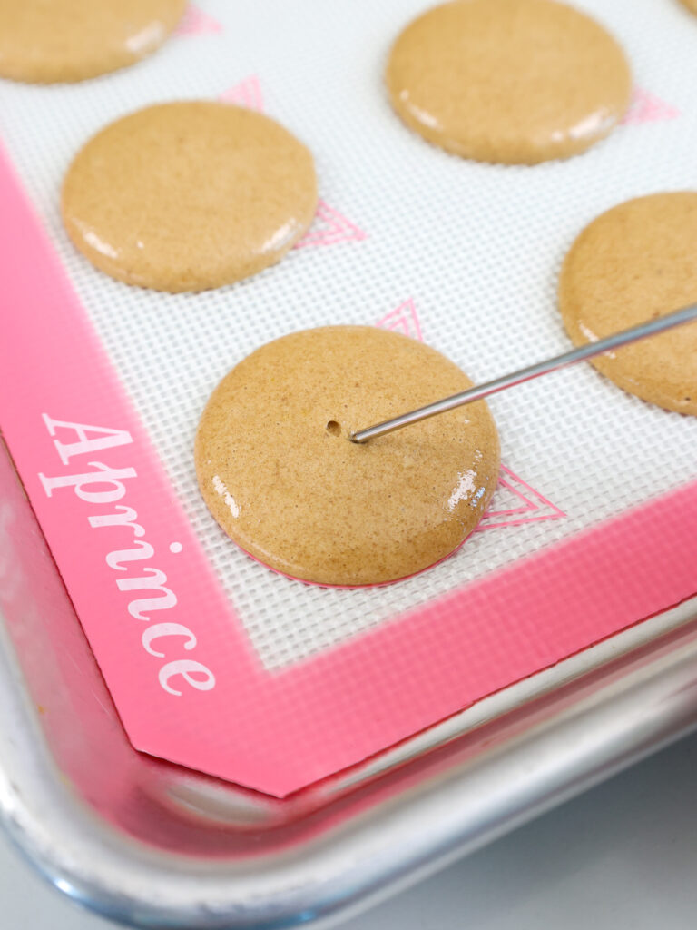 image of a bubble being popped in a macaron shell with a scribe