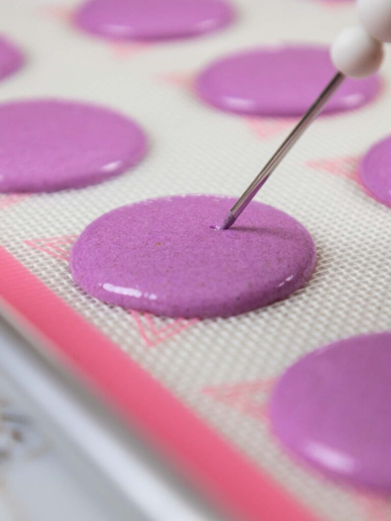 image of a bubble being popped in a french macaron shell with a scribe