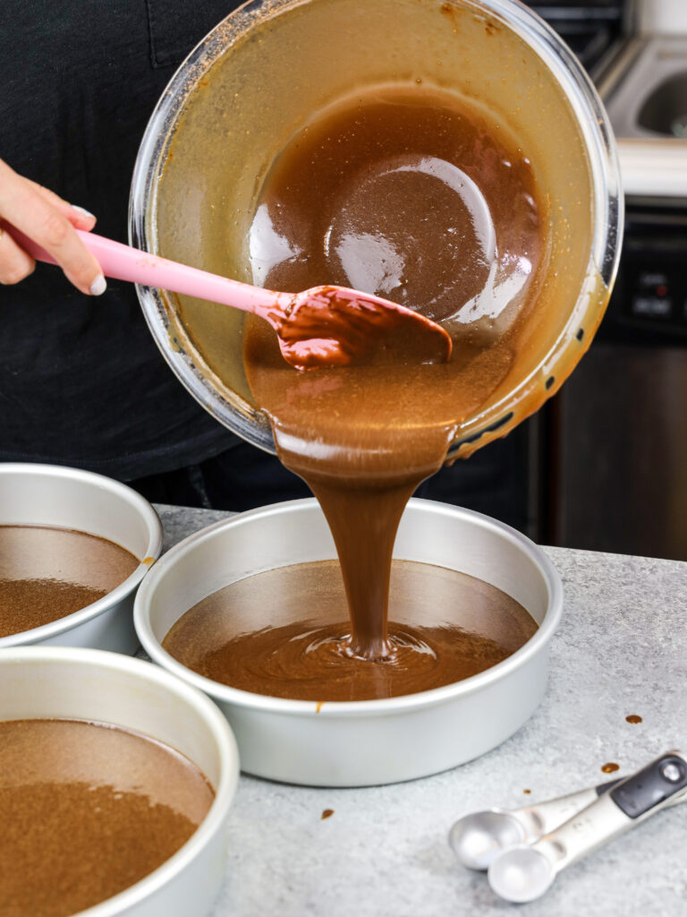 image of my moist chocolate cake batter being poured into 8 inch cake pans