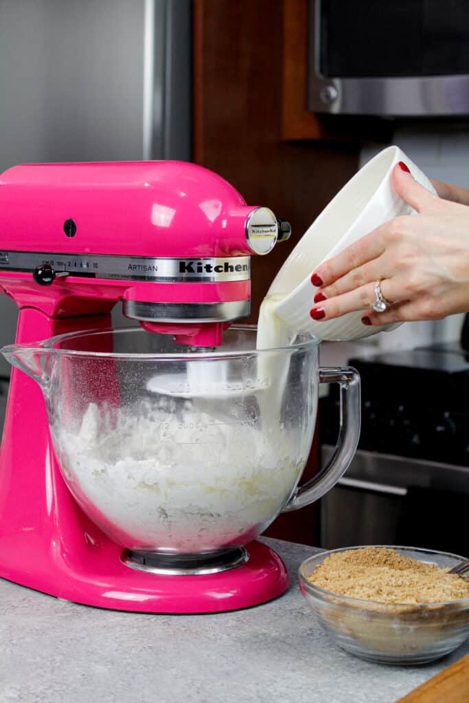 image of milk being poured into cinnamon roll dough, shared to discuss baking subsitutions for whole milk and buttermilk