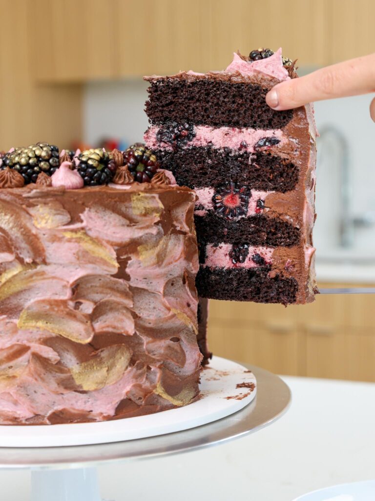 image of a slice of chocolate blackberry cake being served