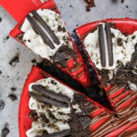 image of red velvet oreo cheesecake that's been cut and is having a slice pulled out to be eaten