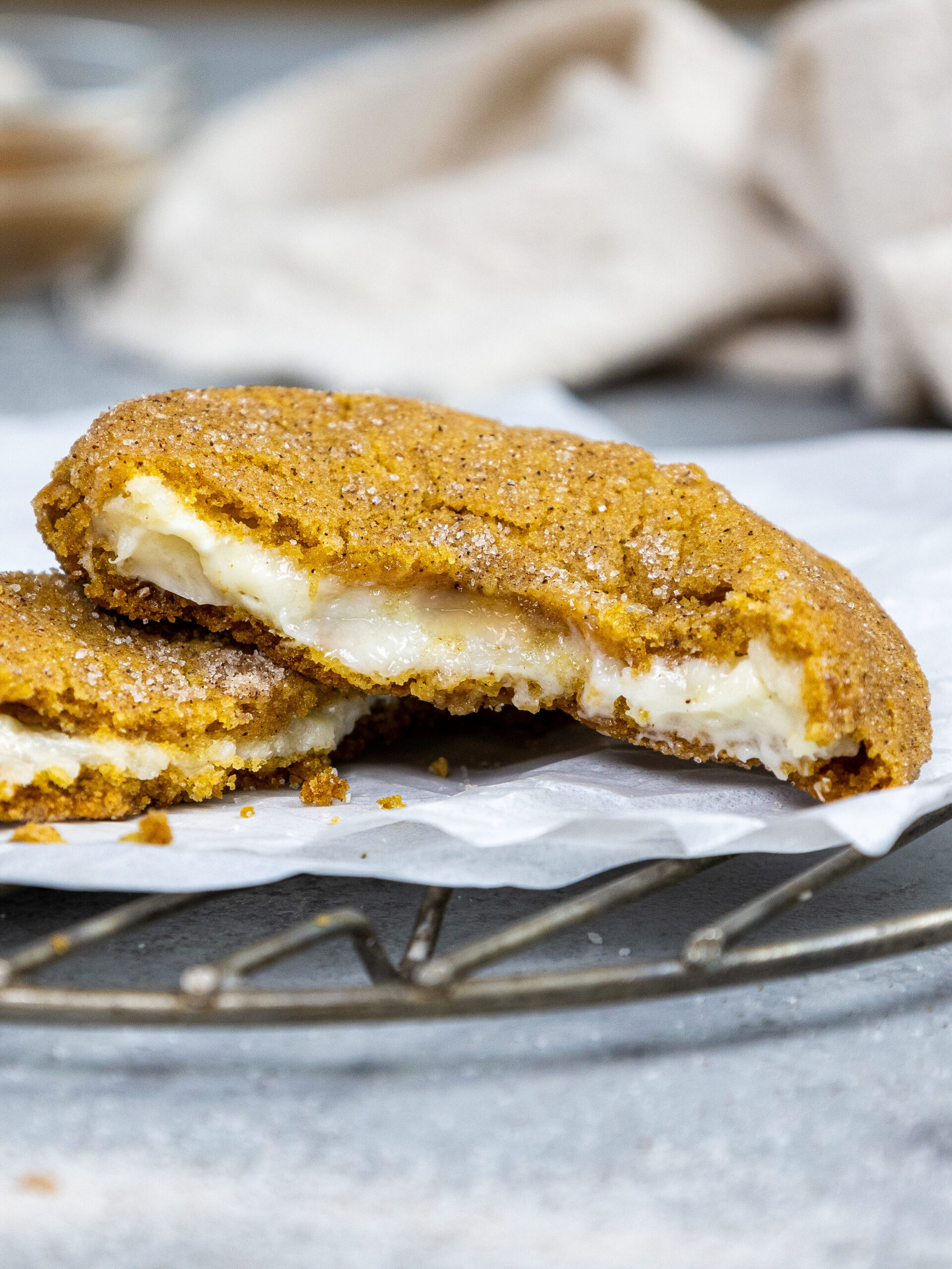 image of a pumpkin cheesecake cookie that's been broken open to show its cheesecake filling