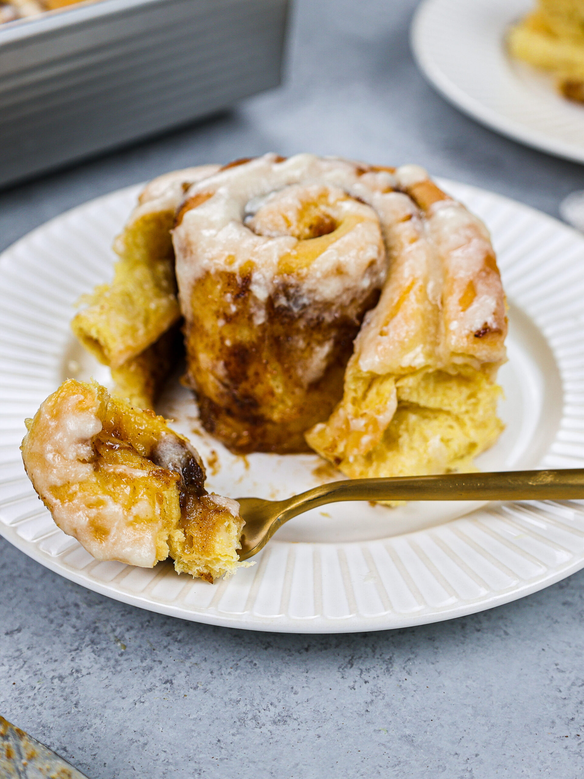 image of a pumpkin pie cinnamon roll that's been cut into to show how soft and tender it is