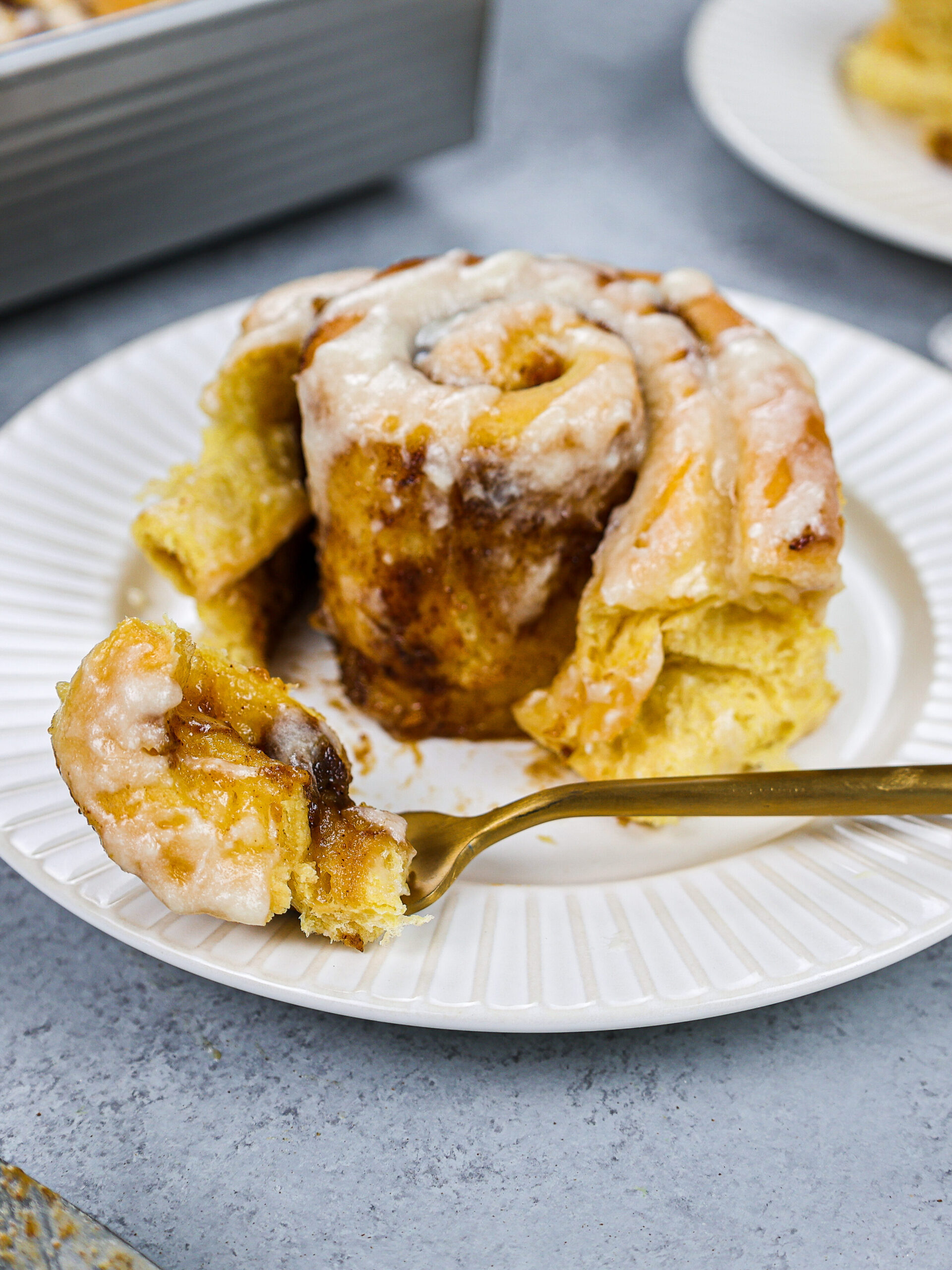 image of a pumpkin pie cinnamon roll that's been cut into to show how soft and tender it is