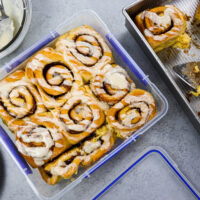 image of pumpkin pie cinnamon rolls that have been place in an airtight container to be frozen and eaten later