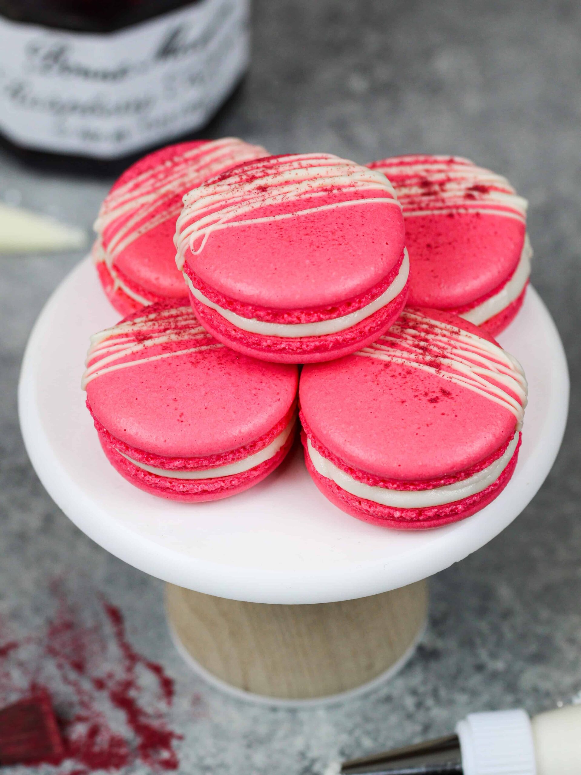 image of raspberry macarons decorated with white chocolate and freeze dried raspberry powder