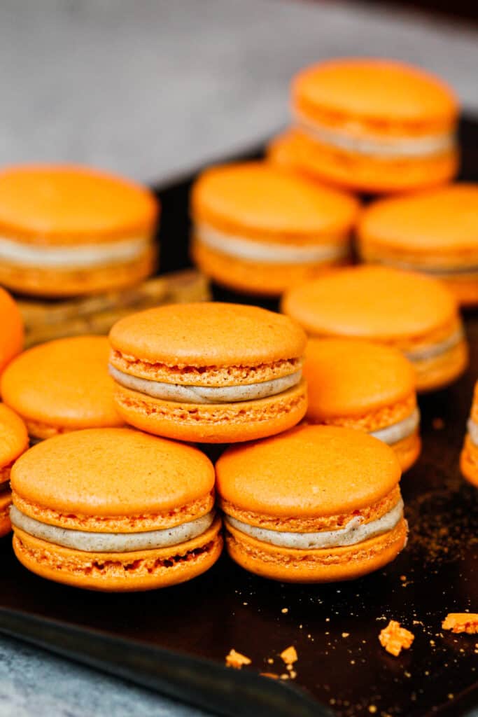 image of pumpkin macarons on a baking tray