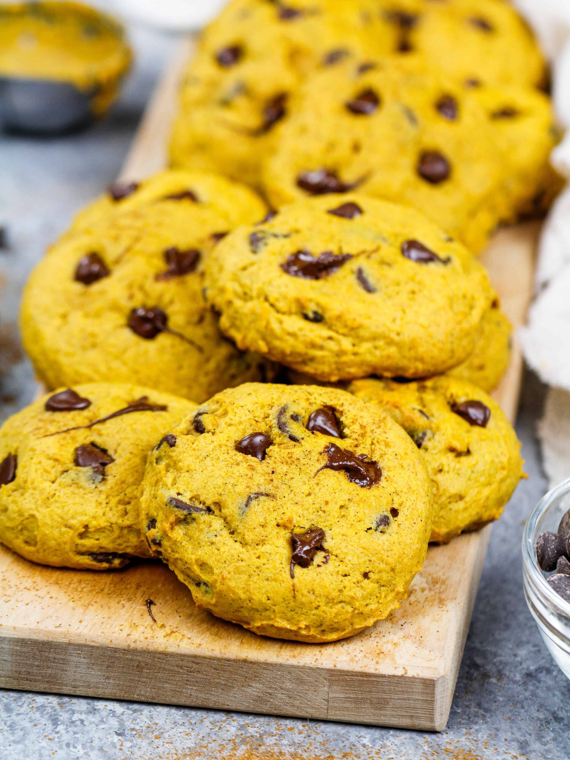 image of vegan pumpkin chocolate chip cookies stacked on a board ready to be eaten