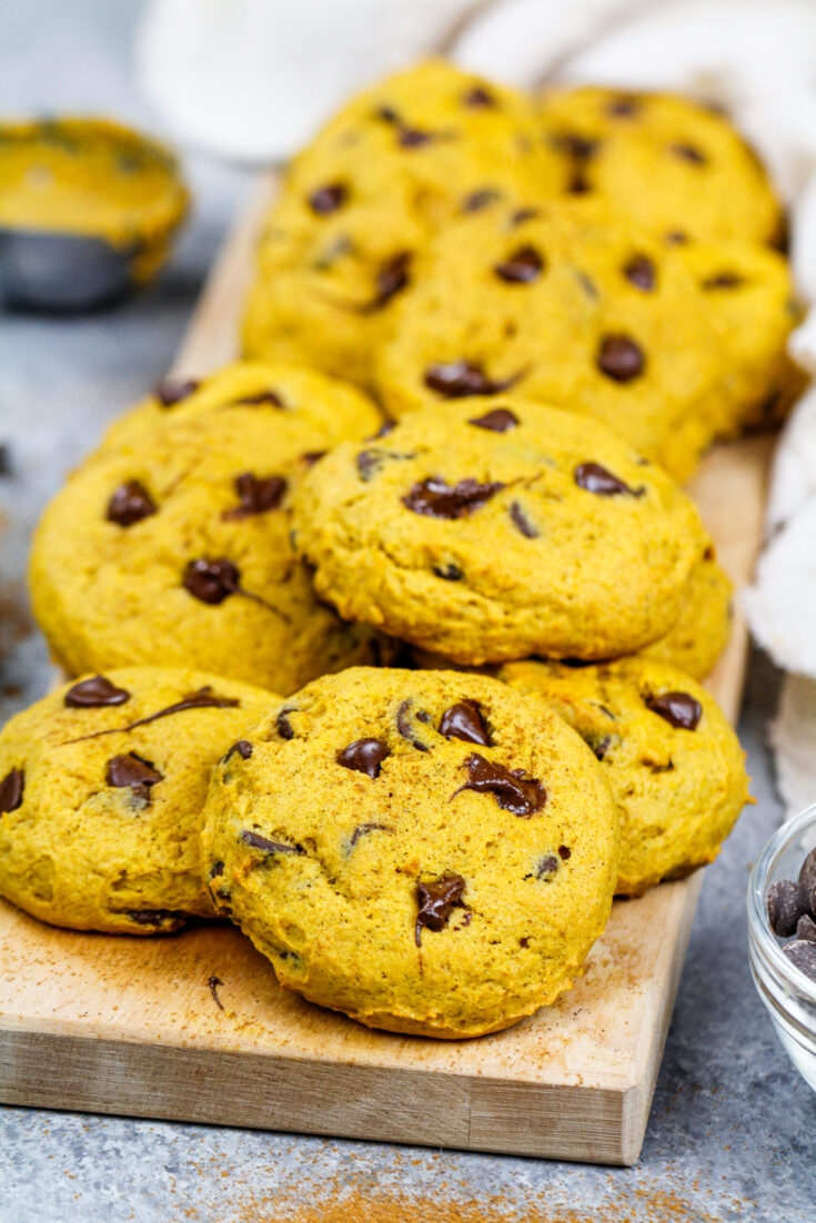 image of vegan pumpkin chocolate chip cookies stacked on a board ready to be eaten