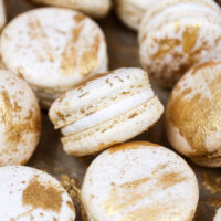 image of vanilla macarons made using the french method and decorated with edible gold paint