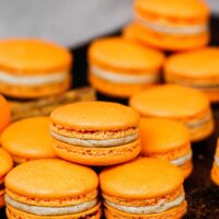 image of pumpkin macarons on a baking tray