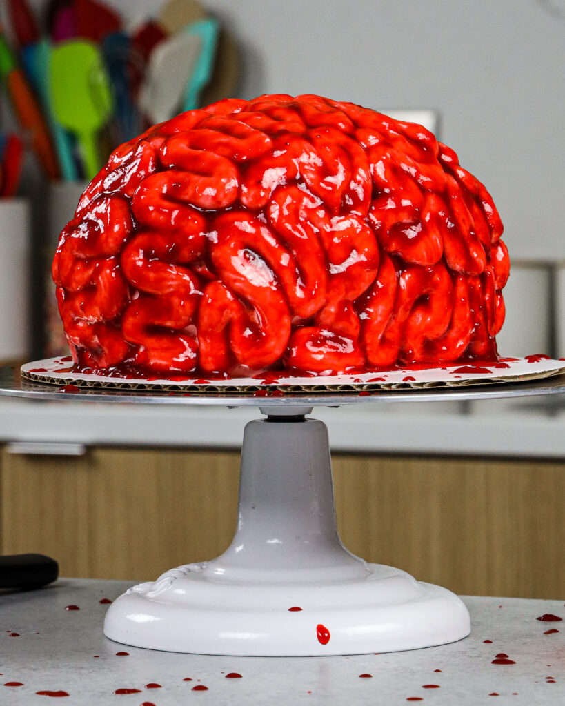 image of a bloody brain cake made for halloween with red velvet cake layers and raspberry jam blood