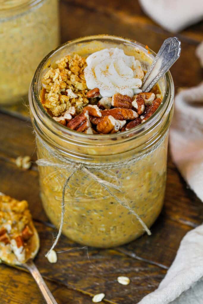 image of pumpkin spice overnight oats made in a mason jar and topped with nuts and granola