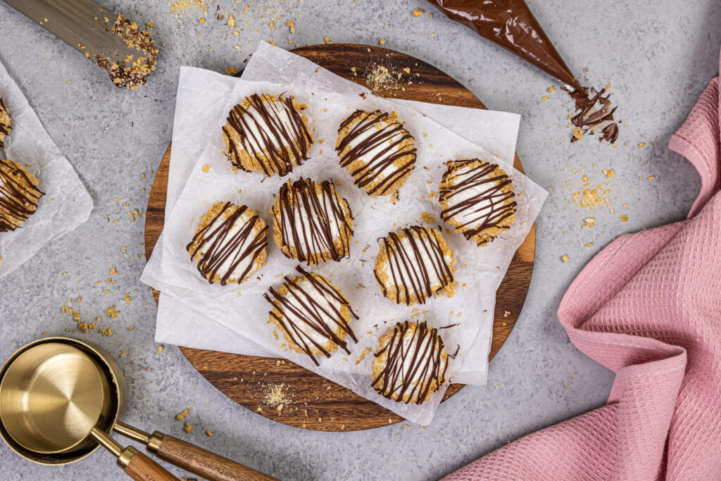 image of no bake cheesecake bites that have been drizzled with melted chocolate