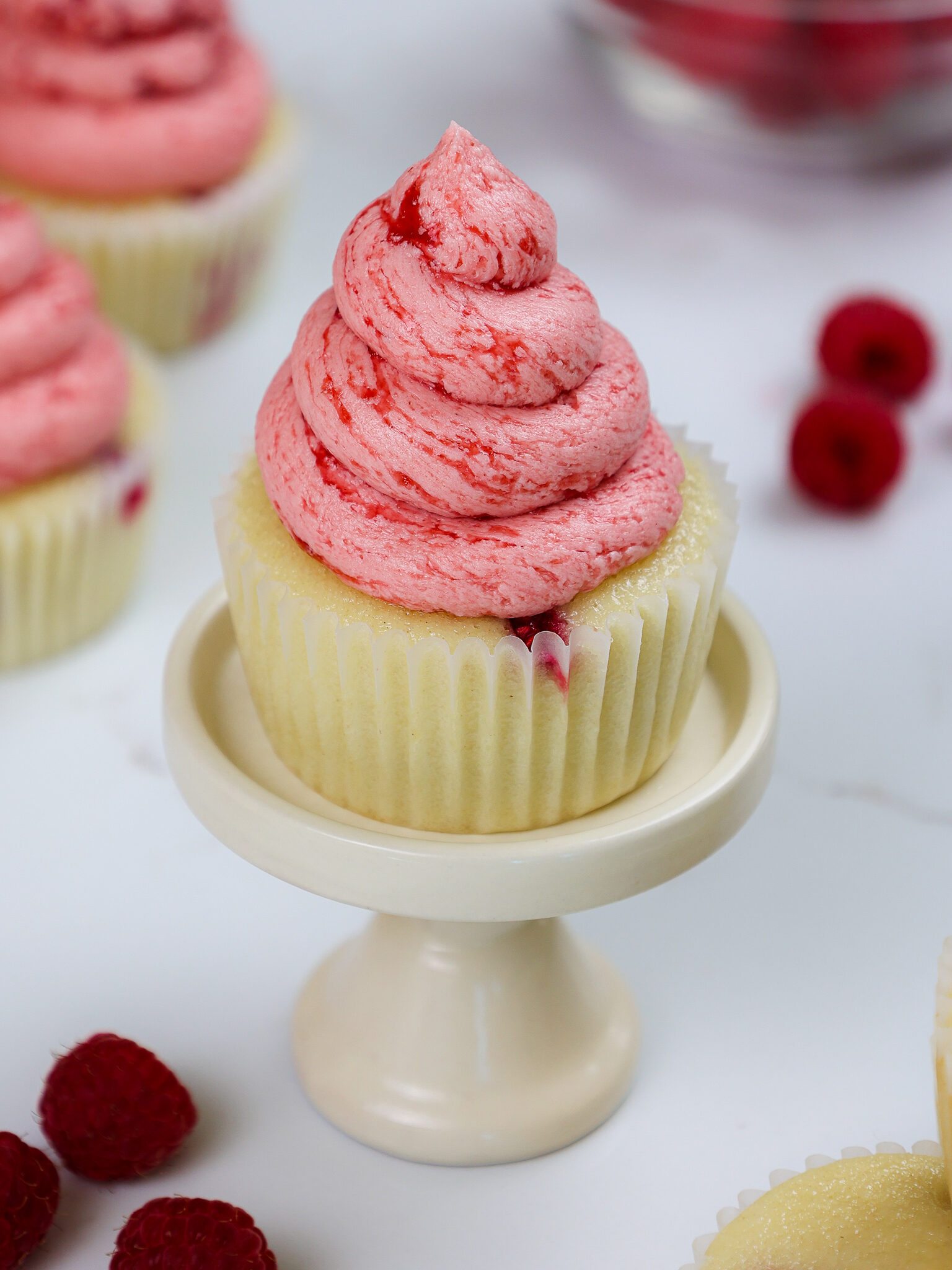 image of raspberry cupcakes made with vanilla cupcakes and raspberry buttercream