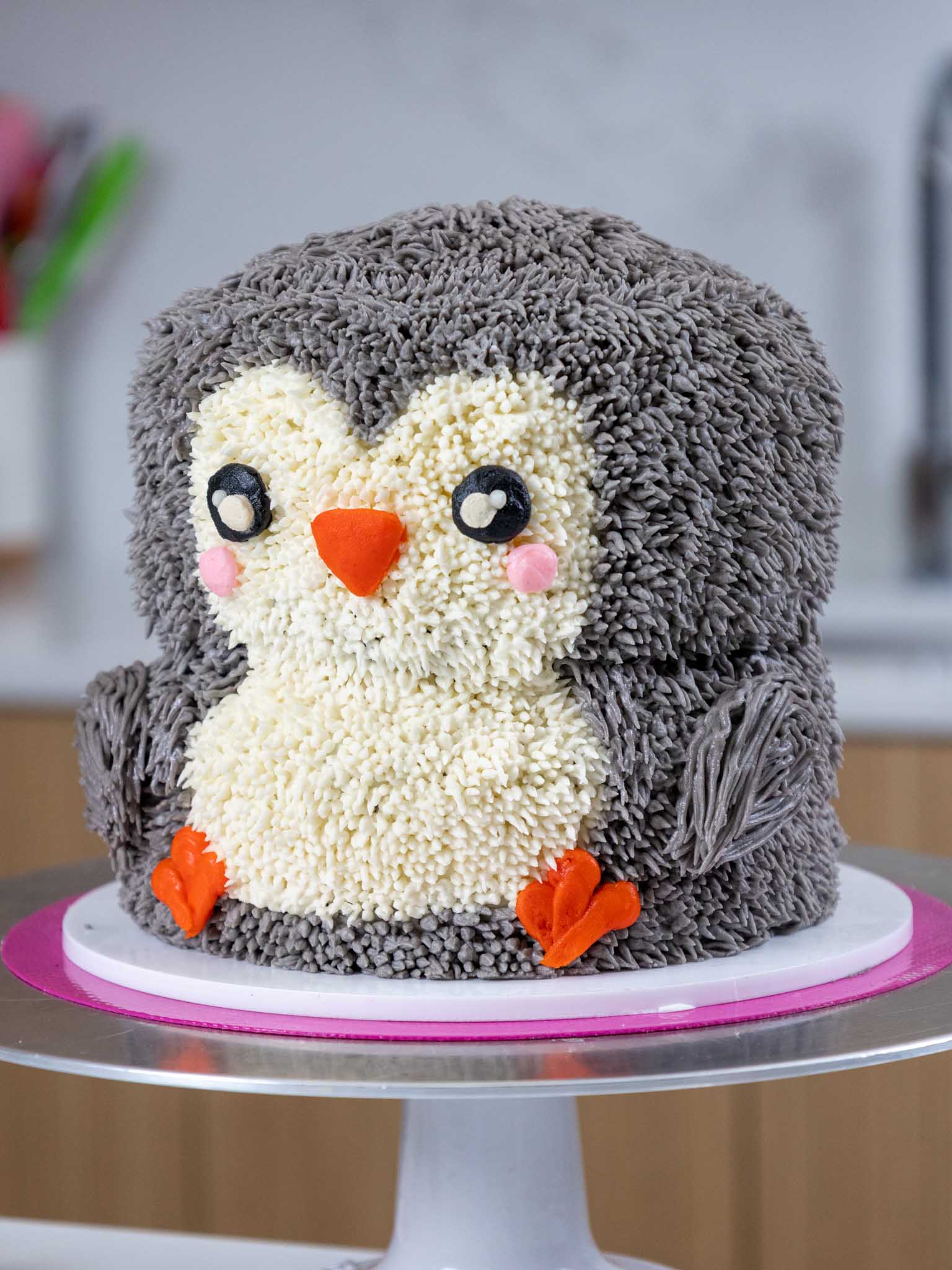 image of an adorable penguin cake made with buttercream frosting