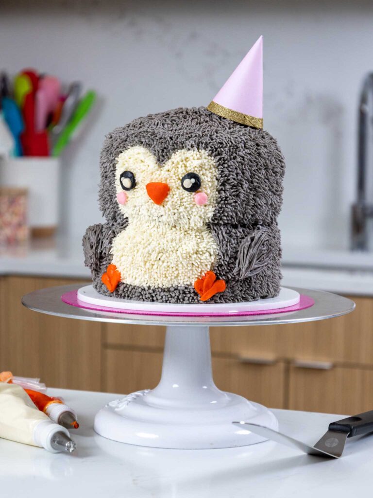 image of an adorable penguin cake made with buttercream frosting