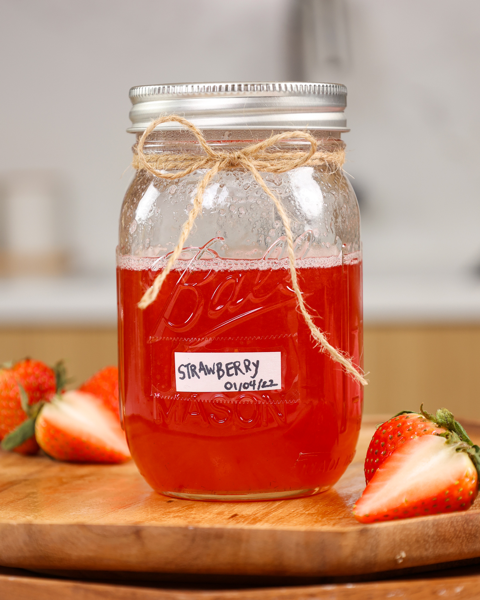 image of strawberry simple syrup in a mason jar