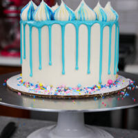 image of a blue drip cake being cut into to show its matching blue cake layers