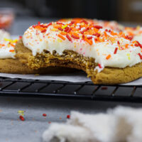 image of soft and chewy frosted gingerbread cookies that have been bitten into to show how delicious they are