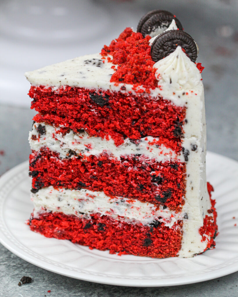 image of a slice of red velvet oreo cake that's frosted with an oreo red velvet cream cheese frosting