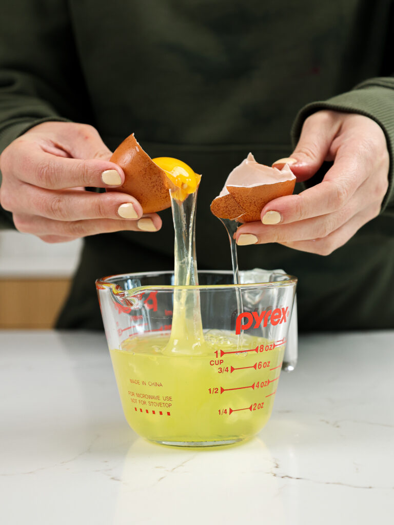 image of an egg white being separated into a container to make french macarons