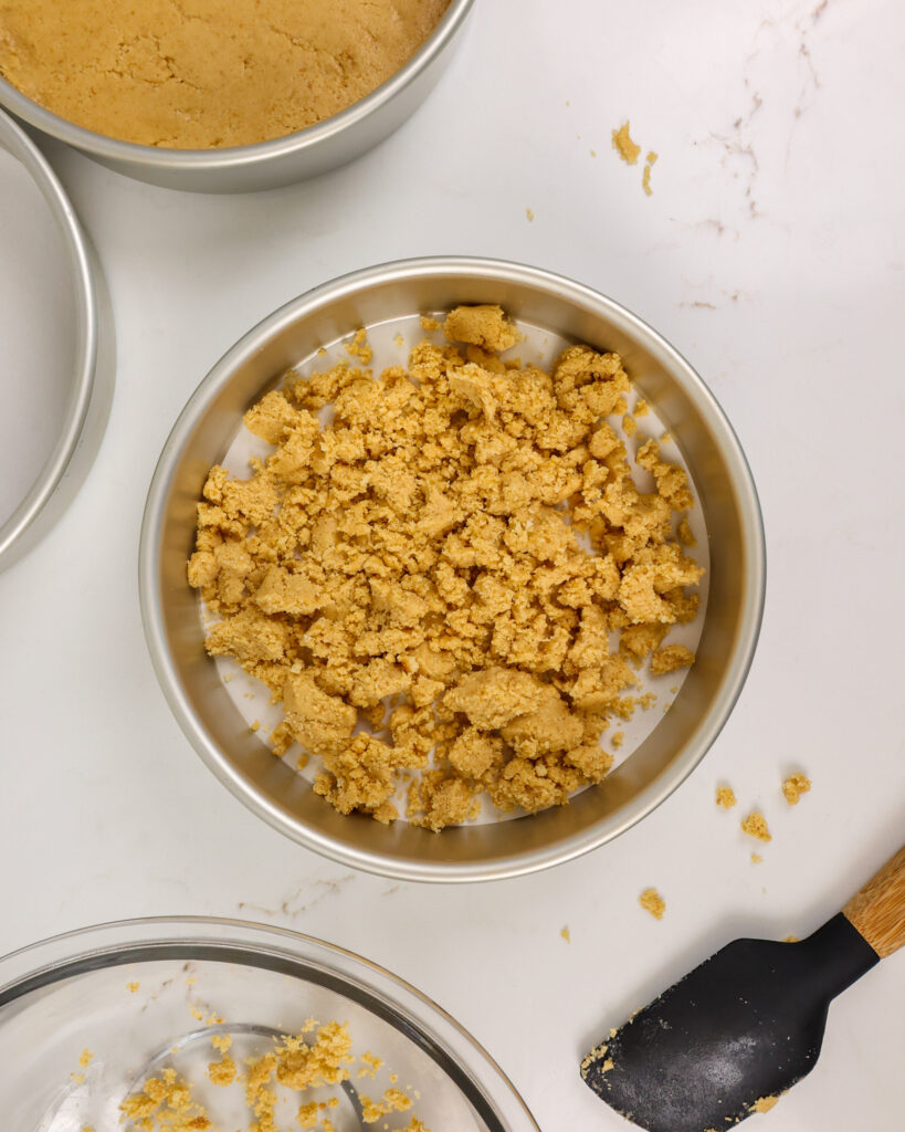 image of shortbread that's been added to a cake pan to make a shortbread crusted cake layer