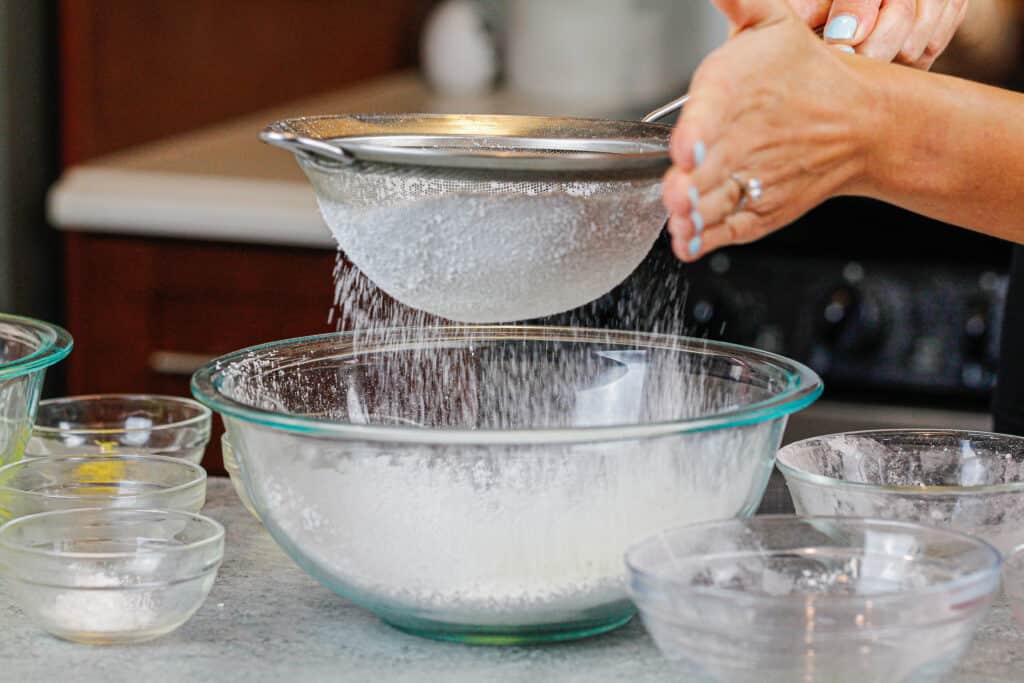 image of dry ingredients being sifted into bowl to make french macarons